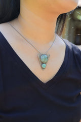 Turquoise triangle pendant worn on a model as a textured oxidized sterling silver statement necklace.