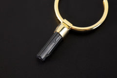 Close-up of Black Tourmaline hoop earrings showing raw striated crystal wands and warm gold-plated silver fittings.