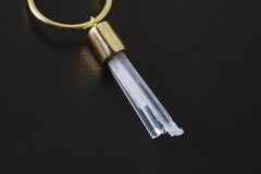 Close-up of Aquamarine hoop earring pendant showing prong-set crystal and warm gold-plated detail.