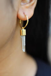 Aquamarine gold-plated sterling silver hoop earring worn on a model as a single pale blue crystal charm.