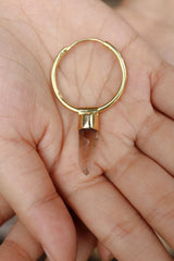 Lemurian Citrine hoop earring pendant held in hand, showing large gold hoop and golden crystal point.