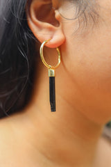 Black Tourmaline gold-plated sterling silver dangle hoop earring worn on a model as a single crystal charm.