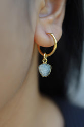 Blue Tourmaline single earring shown worn on the ear, with gold-plated hoop and raw blue gemstone drop.
