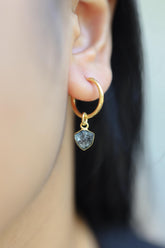 Blue Tourmaline gold-plated sterling silver dangle hoop earring worn on a model as a single gemstone charm.