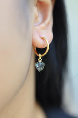 Blue Tourmaline gold-plated sterling silver dangle hoop earring worn on a model as a single gemstone charm.