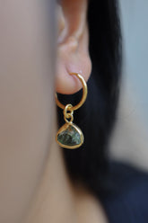 Green Tourmaline gold-plated sterling silver hoop earring worn on a model as a single dangle charm.