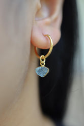 Blue Tourmaline gold-plated sterling silver hoop earring worn on a model as a single dangle charm.