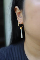 Australian Aquamarine hoop earrings shown worn on the ear, with gold-plated silver hoops and pale blue gemstone drops.