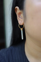 Australian Aquamarine hoop earrings shown worn on the ear, with gold-plated silver hoops and pale blue gemstone drops.