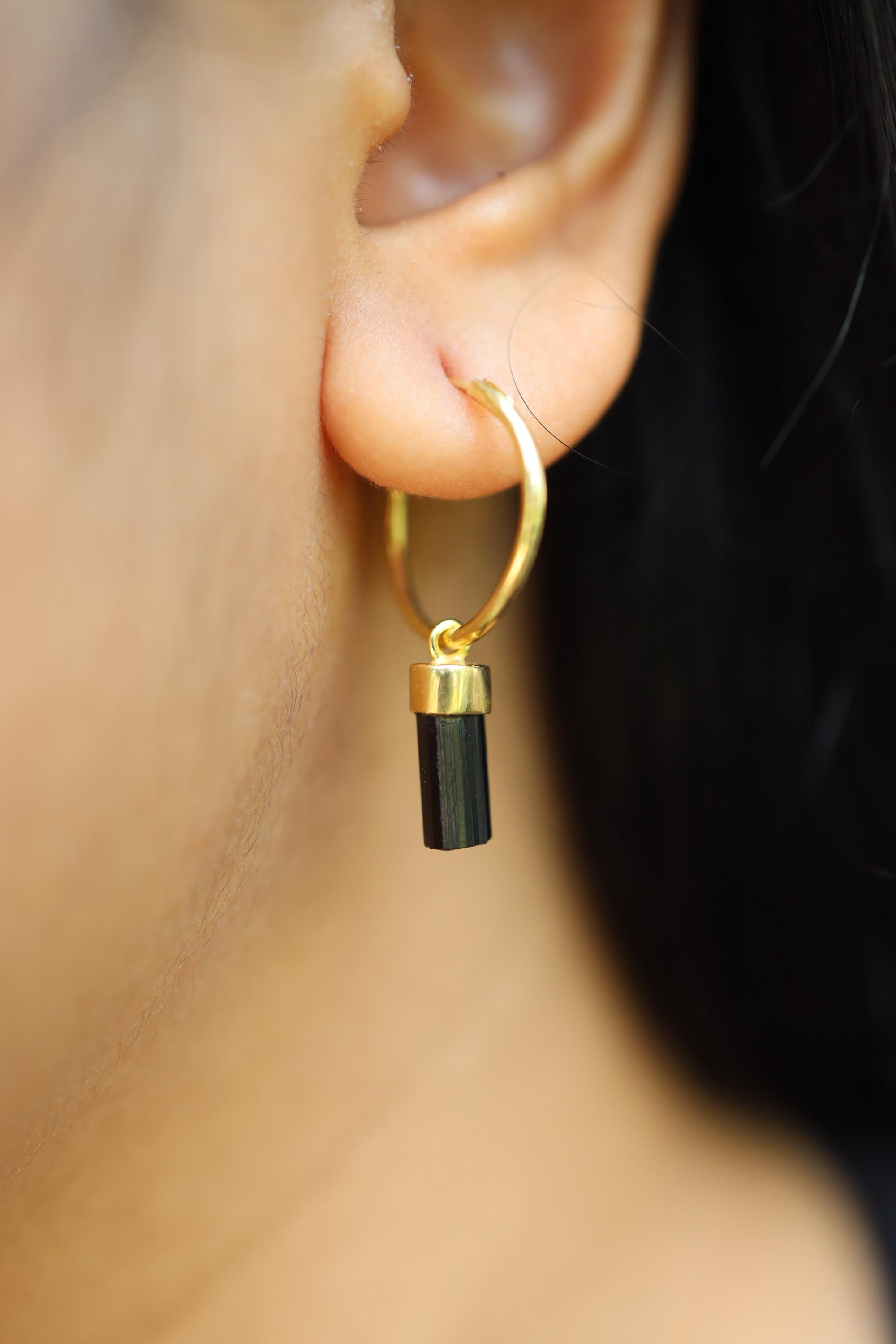 Black Tourmaline gold-plated sterling silver hoop earring worn on a model as a single dangle charm.