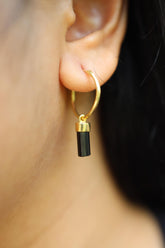 Black Tourmaline gold-plated sterling silver hoop earring worn on a model as a single dangle charm.