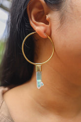 Angel Aura Quartz gold-plated sterling silver dangle hoop earring worn on a model as a single iridescent crystal charm.