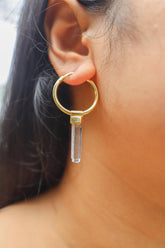 Clear Quartz gold-plated sterling silver dangle hoop earring worn on a model as a single crystal charm.