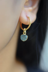 Blue Tourmaline slice gold-plated sterling silver hoop earring worn on a model as a single dangle charm.
