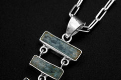Close-up of raw Aquamarine pendant in hammered 925 sterling silver, showing the traditional bail and open-back bezel settings.