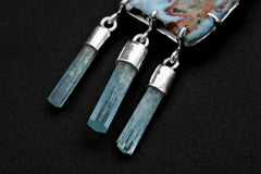 Close-up of three capped Aquamarine stick dangles beneath a Larimar pendant, set in high-shine 925 sterling silver.