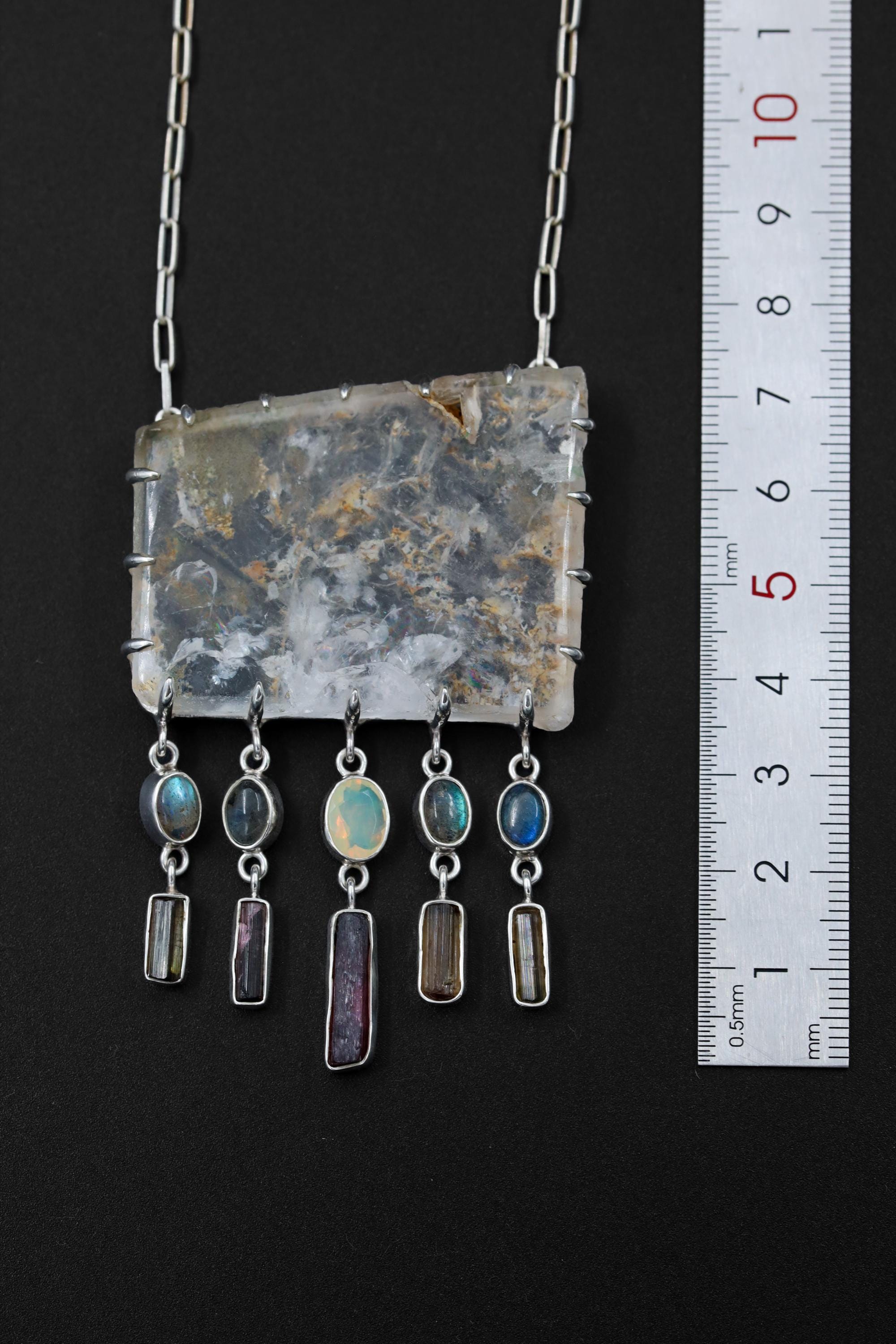 Rainbow Inclusion Quartz Labradorite Tourmaline Opal necklace shown beside a ruler for scale, with large Quartz centrepiece and five crystal dangles.