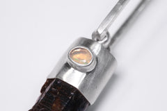 Close-up of Ethiopian Opal accent set in sterling silver above a Blue Apatite crystal point pendant.