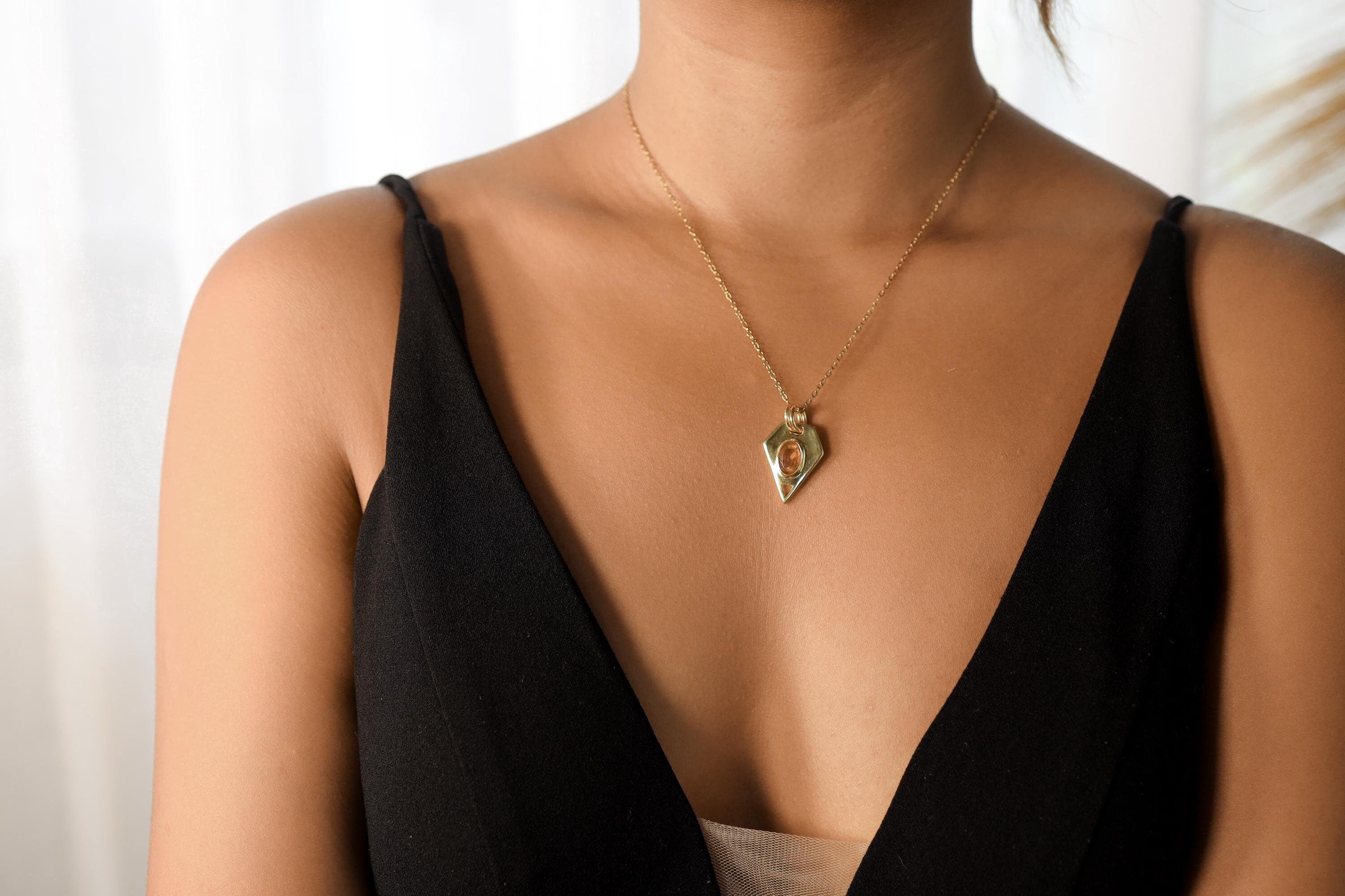Faceted Red Kyanite slice pendant in 18k gold-plated sterling silver, shown worn on a necklace with compact geometric shape.