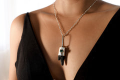 Brown Dravite Tourmaline Diamond pendant displayed with clear quartz backdrop, sterling silver chain, and textured silver setting.