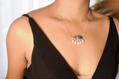 Charoite Moonstone eye necklace shown worn on the chest, with sterling silver chain and five luminous dangle stones.