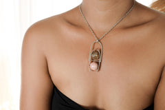 Rhodochrosite and Golden Rutile Quartz pendant in high-shine 925 sterling silver shown on a dark background with black cotton cord.