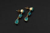 Handmade 18k gold-plated 925 sterling silver Blue Apatite drop earrings shown on a dark background, with raw blue stones and teardrop crystal dangles.