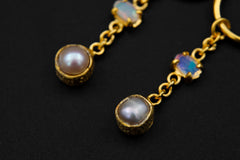 Detailed view of Ethiopian Opal and Pearl dangle earrings showing 18k gold-plated silver chain and gemstone glow.