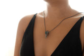 Vera Cruz Amethyst Emerald Pendant shown worn on the chest with oxidized sterling silver and dark hoop chain.