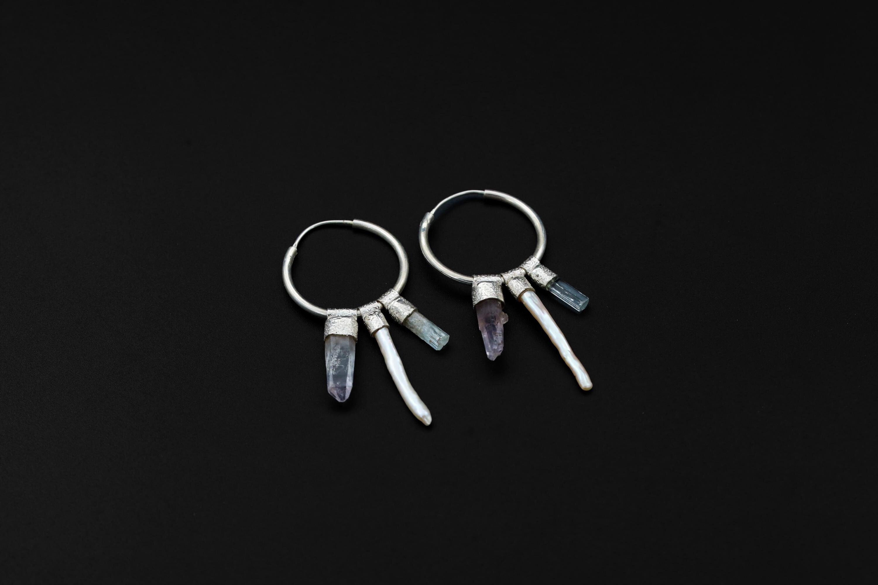 Celestial Gatherer crystal stack hoop earrings shown on dark background with sterling silver hoops and mixed gemstone dangles.
