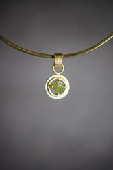 Raw AAA Grade Peridot claw pendant in 18k gold-plated sterling silver, shown on a black background with vivid green stone.