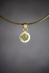 Raw AAA Grade Peridot claw pendant in 18k gold-plated sterling silver, shown on a black background with vivid green stone.