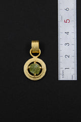 Raw Peridot claw pendant shown beside a ruler for scale, measuring approximately 3 cm total length including bail.