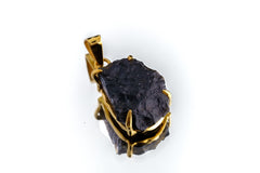 Cosmic Relic Darwin Glass pendant shown on white background with raw black tektite and gold-plated silver.