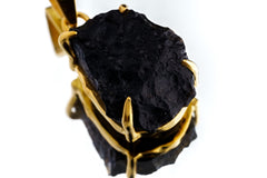 Close-up of Darwin Glass Tektite pendant showing dark impact glass texture and gold-plated claw setting.