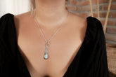 Larimar teardrop pendant worn on a model with hammered sterling silver and soft blue gemstone centre.