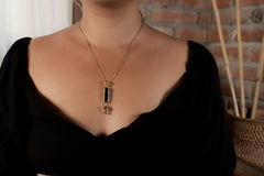 Layered gemstone pendant shown worn on a necklace, featuring Moonstone, Tourmaline, Smoky Quartz, and Blue Sapphire.