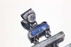 Close-up of Moonstone, Kyanite, Aquamarine, Apatite, and Amethyst in a long oxidized sterling silver pendant.