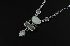 Rose Quartz Opal Aquamarine Moonstone necklace shown on a dark background with linked sterling silver gemstone settings.