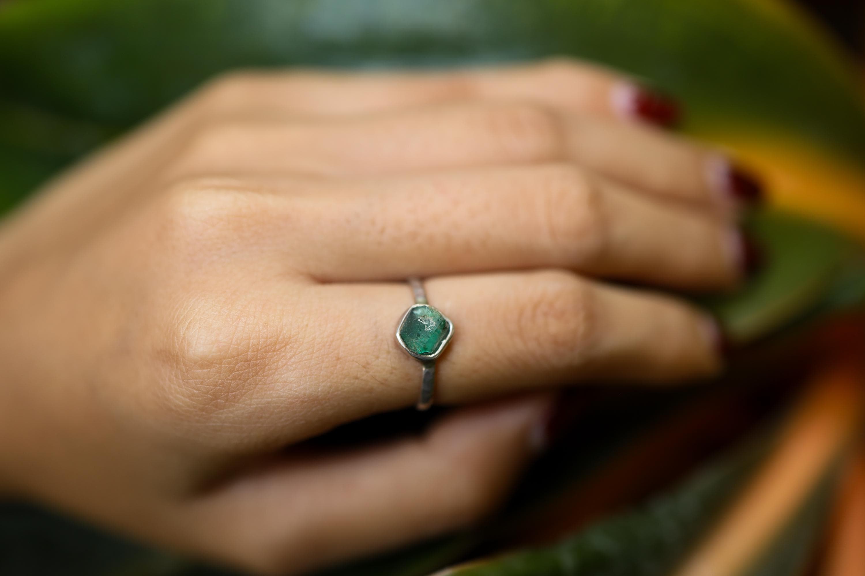 Australian Raw Emerald ring shown worn on the hand as a delicate Heart Chakra stacking ring in handmade silver.