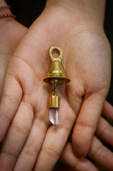 Clear Quartz Mini Prayer Bell held in hand with 18k gold-plated bronze body and tiny crystal point.