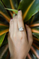Sunstone sterling silver ring shown on clear quartz, with pale golden feldspar stone and handmade polished silver setting.