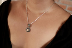 Small South Sea Pearl claw pendant shown worn on a necklace, set in oxidized sterling silver with a dark handmade finish.
