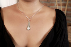 Blue Moonstone teardrop pendant worn on a model with hammered sterling silver and soft luminous gemstone centre.
