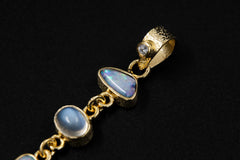 Close-up of gold-plated gemstone pendant showing Australian Opal Doublet, Blue Moonstone, Herkimer Diamond, and handmade links.