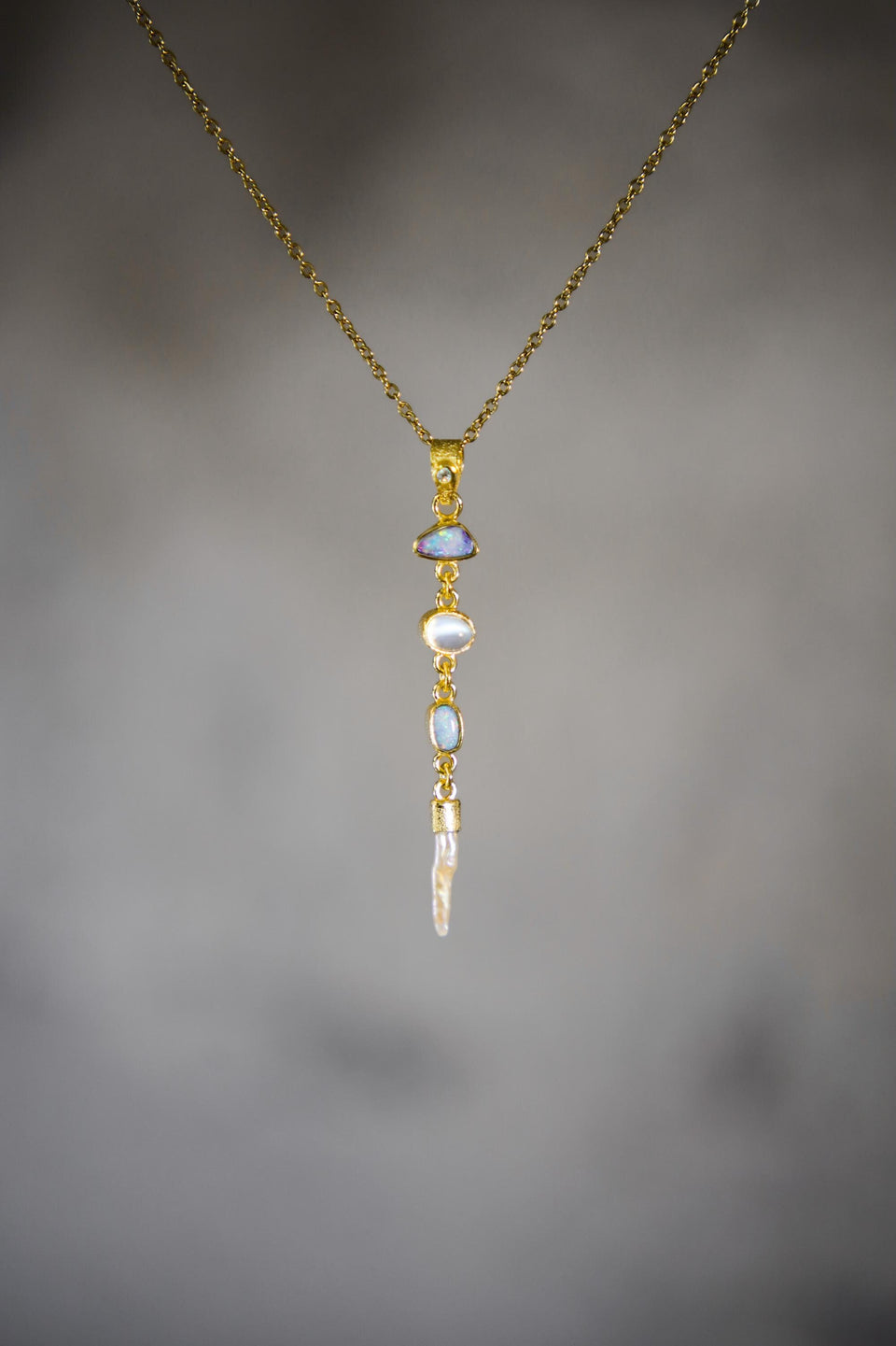 Zircon Opal Moonstone Pearl pendant shown on a gold-toned necklace, with long 18k gold-plated vertical gemstone design.