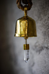 Close-up of Clear Quartz prayer bell showing gold-plated bronze body, internal chain, and suspended crystal point.
