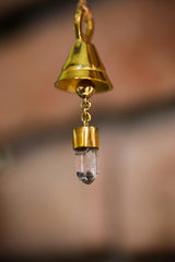 Clear Quartz mini prayer bell hanging close-up with gold-plated bronze finish and crystal point inside.