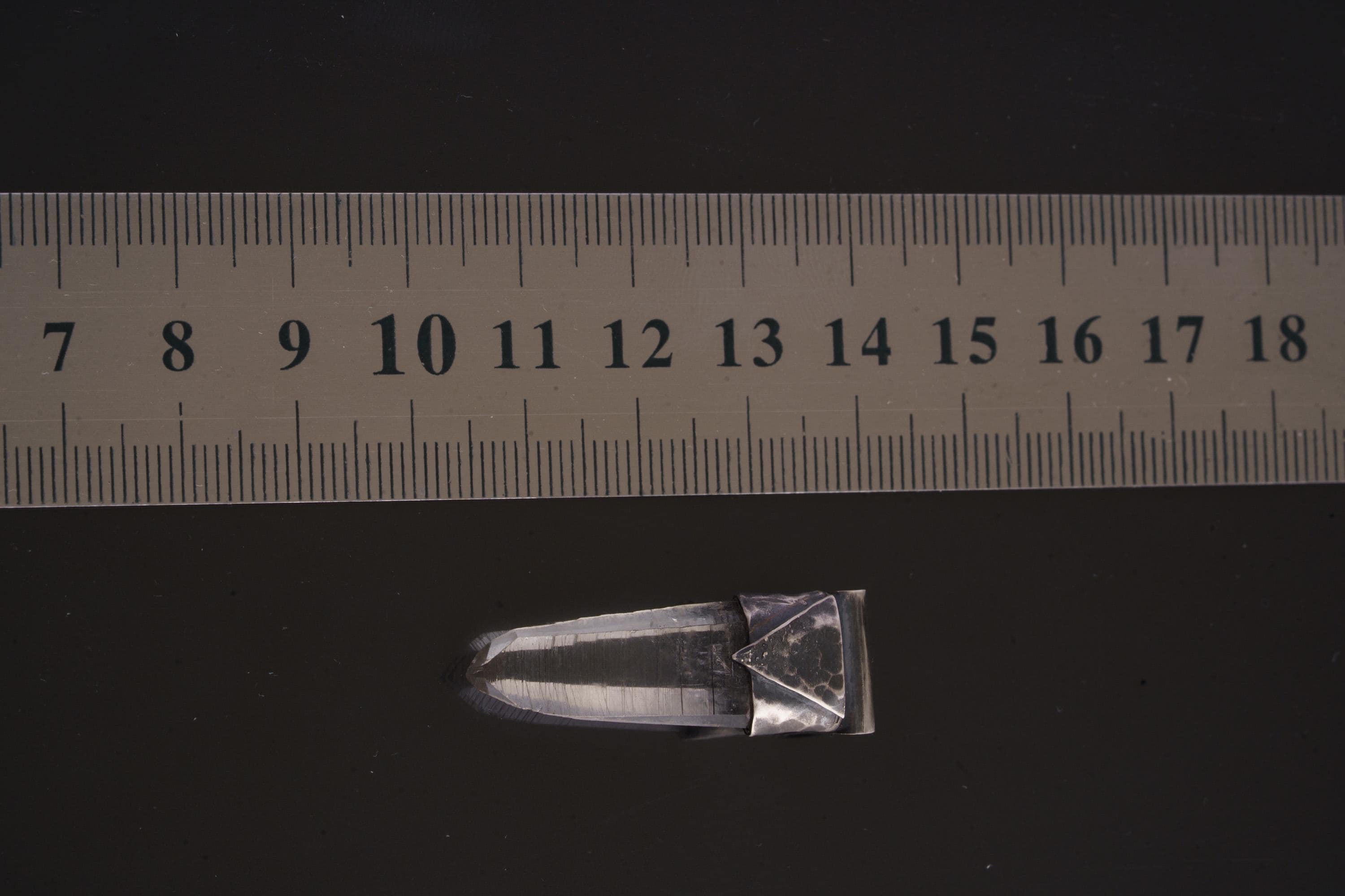 Water Clear Nepalese Inclusion Quartz Pendant shown beside a ruler for scale with oxidized silver cap and clear crystal body.
