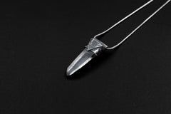 Water Clear Nepalese Inclusion Quartz Pendant shown on black background with black cotton necklace and raw clear Quartz point.